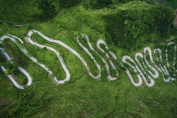 Winding road from the high mountain pass in Guizhou, China. Great road trip trough the dense woods. Aerial view.