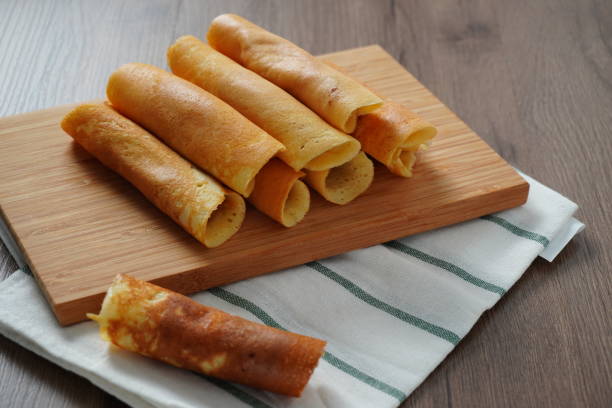 istock filled pancake roll assorted flavors on bamboo chopping board placed on white and green striped cloth on wooden table 1206359833