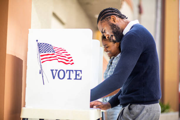 millenial black man and woman voting in election - voting fotografías e imágenes de stock