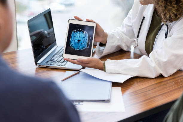 невролог проверяет мрт головного мозга пациента - brain mri scan alzheimers disease medical scan стоковые фото и изображения