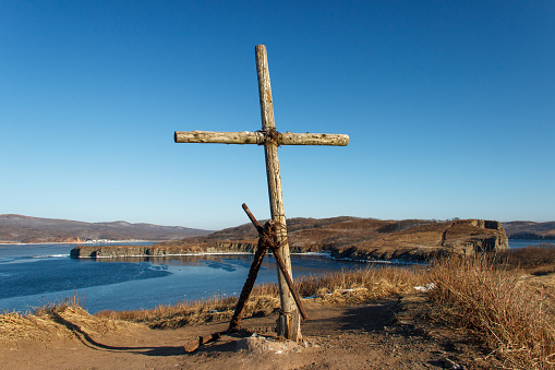The old monument is a wooden cross and an old rusty anchor on a cliff at the extreme end of Tobizin cape on the Russian island in Vladivostok.