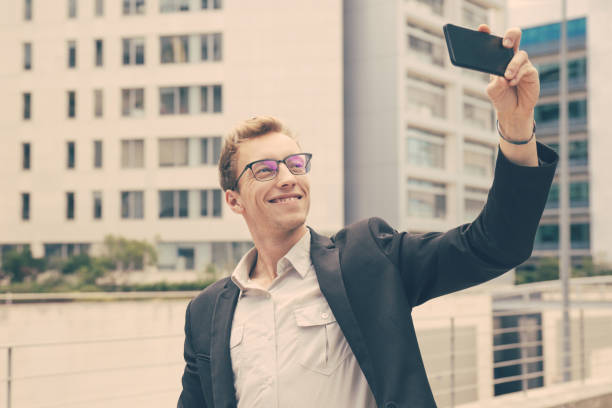 istock Smiling satisfied businessman taking selfie 1206366601