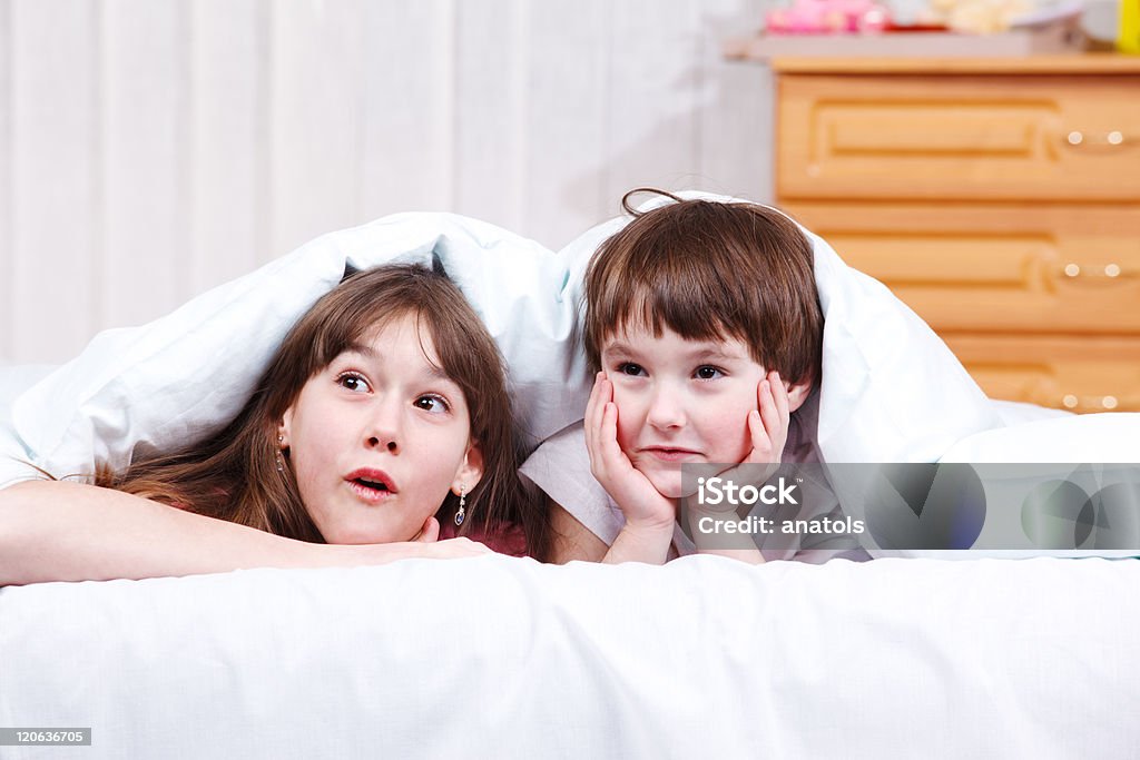 Surprised children Two surprised children in bed Beautiful People Stock Photo