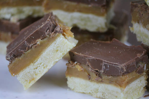 bild von hausgemachten millionär shortbread rezept tablett backen kuchen in quadrate geschnitten, haufen von gebackenem kurzbrot mit karamell-toffee und milchschokolade gekrönt - shortbread caramel chocolate candy biscuit stock-fotos und bilder