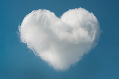 Heart shaped cloud in the blue sky with space for text, valentines day background.