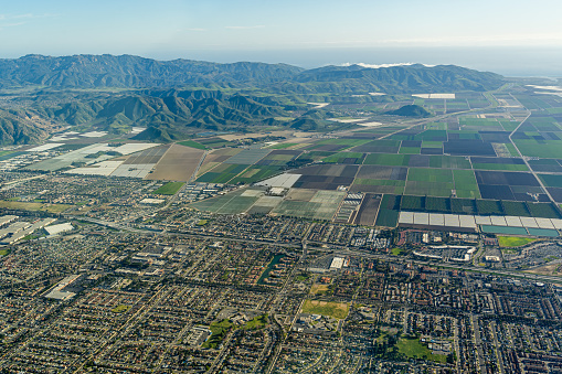 Aerial view above the town of Camarillo and the farms above Oxnard California looking to the South with Highway 101 in the foreground and S Lewis Road. Pleasant Valley Road. And Pleasant Valley Fields