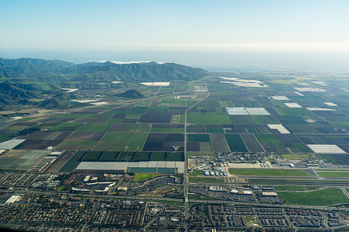 Aerial view above the town of Camarillo and the farms above Oxnard California looking to the South with Highway 101 in the foreground and S Lewis Road. Pleasant Valley Road. And Pleasant Valley Fields with Camarillo Airport and Las Posas Road