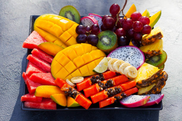 istock Tropical fruits assortment on a plate. Grey background. Close up. 1206377630