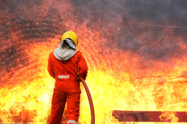 소방관 훈련, 비상 상황에서 화재와 싸우는 팀 연습. 소방관이 불꽃을 통해 실행 물 호스를 수행 - rubber band 뉴스 사진 이미지