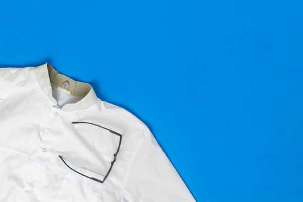 istock simple classic white doctor uniform clothes and eyeglasses flat lay on the table 1206381779