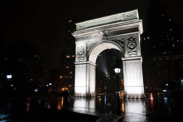 雨の中で夜にワシントンスクエアパークアーチニューヨークは雨の中で傘で人々のシルエット - new york city new york state greenwich village washington square triumphal arch ストックフォトと画像