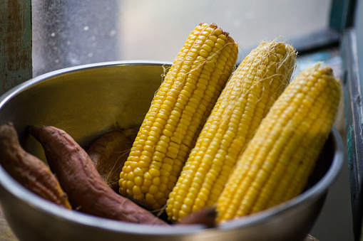 Corn and sweet potatoes placed besides a window of a kitchen in a Hutong alley in Beijing, China