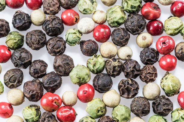 istock Black, white, green and red peppercorns isolated on white background. 1206385031