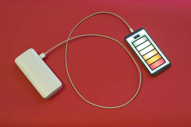 Smartphone is charging with power bank on red background