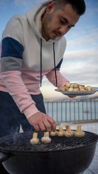 istock Man cooking  mushroom on bbq 1206385791