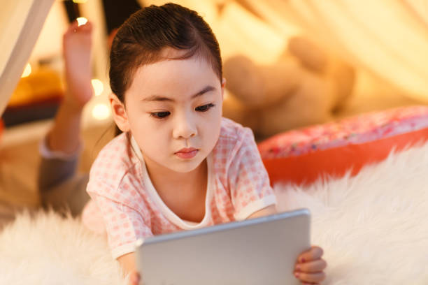 istock Cute little girl looking at Tablet PC 1206386250