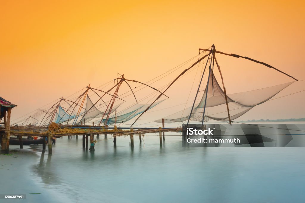 Traditional chinese fishing nets in Kochi, India at sunrise Chinese fishing nets in Fort Kochi, Kerala, India. Kochi - India Stock Photo