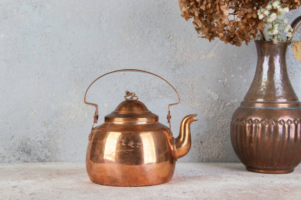 Vintage copper teapot on concrete background. Food photography props and copy space for text.