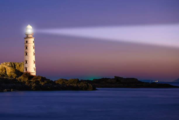 Lighthouse on sea sunset Lighthouse on sea sunset with light beacon at night landscape beacon photos stock pictures, royalty-free photos & images