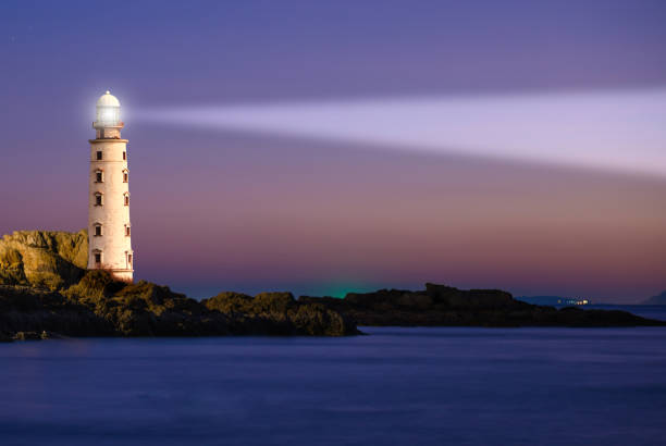Lighthouse on sea sunset Lighthouse on sea sunset with light beacon at night landscape Beacon stock pictures, royalty-free photos & images