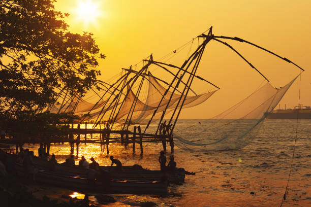 Traditional chinese fishing nets in Kochi, India at sunrise Chinese fishing nets in Fort Kochi, Kerala, India. cochin kerala india chinese fishing net stock pictures, royalty-free photos & images