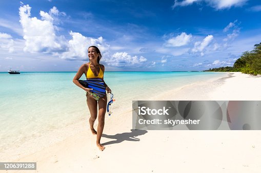 istock Happy woman leaving the sea with her diving equipment in summer day. 1206391288