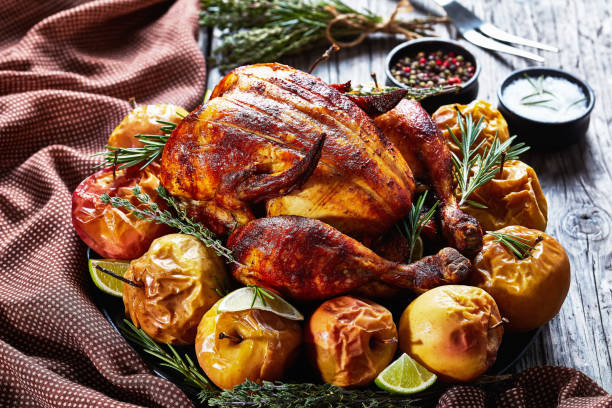 istock whole roasted chicken served on a black platter with baked apples 1206391709