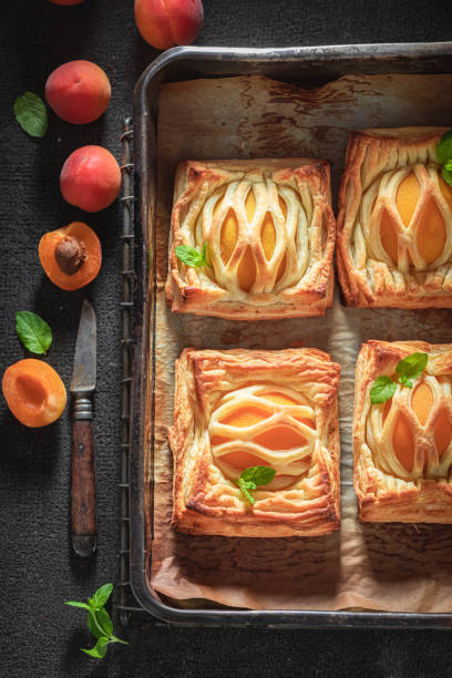 istock Sweet puff pastry with powdered sugar and fresh peaches 1206393758