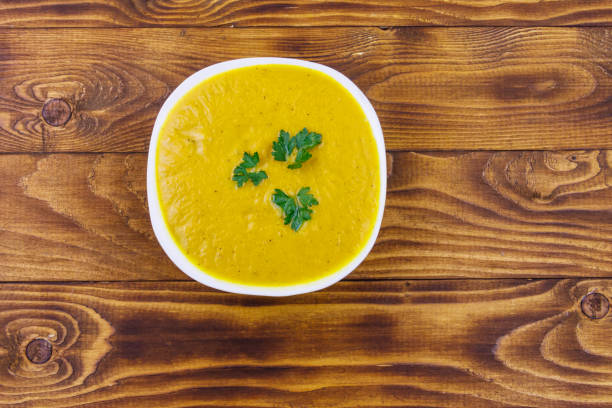 istock Pumpkin soup on a wooden table. Top view 1206395688