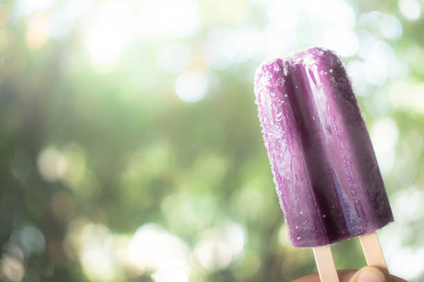 istock Grape flavored popsicle against blur nature background 1206396352