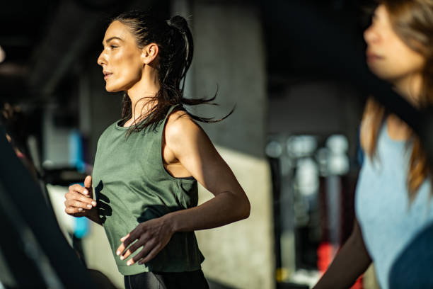istock Determined athletic woman running on treadmill in a gym. 1206397854