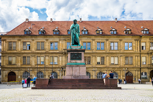Stuttgart, Germany, August 15, 2019, Cobblestone square schillerplatz with statue of famous german poet friedrich schiller as memorial monument with many people visiting landmark