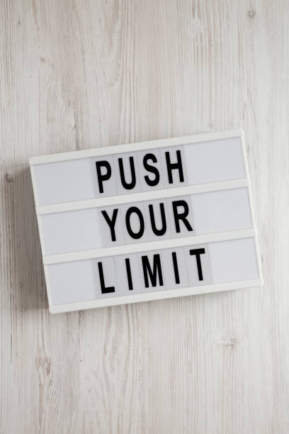 istock 'Push your limit' words on a lightbox on a white wooden background, top view. Overhead, from above, flat lay. 1206399490