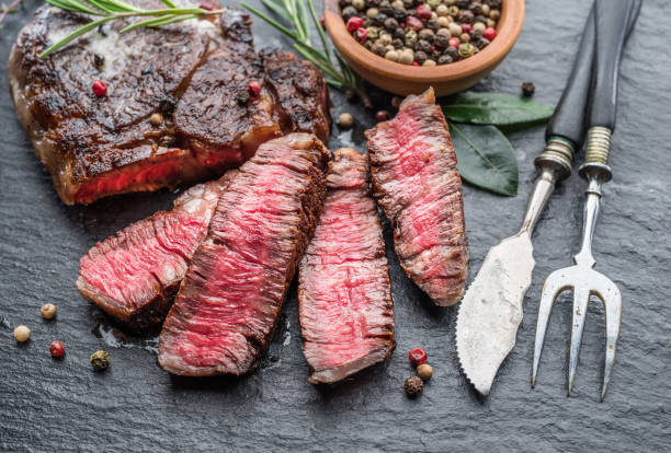 istock Medium rare Ribeye steak with herbs on graphite board. 1206399795