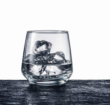 Glass of alcohol with ice. Monochrome picture.