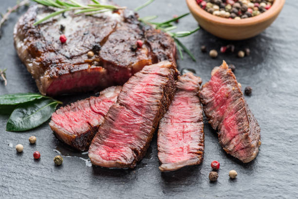 istock Medium rare Ribeye steak with herbs on graphite board. 1206400938