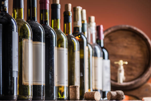 istock Wine bottles in row and oak wine keg. 1206401169