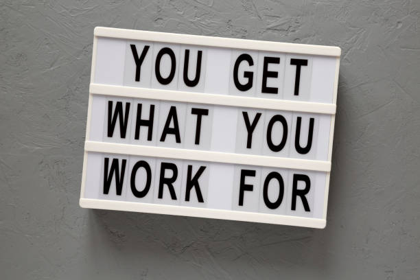 istock 'You get what you work for' words on a lightbox on a gray surface, top view. Overhead, from above, flat lay. 1206402202