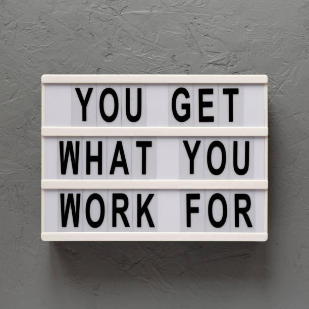 istock 'You get what you work for' words on a lightbox on a gray background, top view. Overhead, from above, flat lay. Close-up. 1206402414