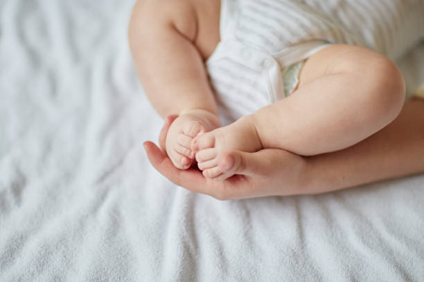 istock Mother's hands carefully keeping baby's foot with tenderness 1206402419