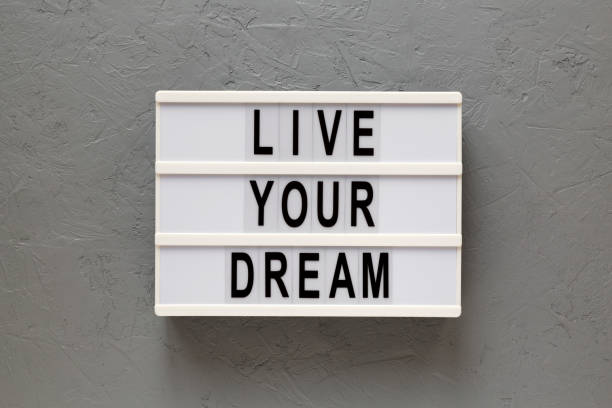 istock 'Live your dream' words on a lightbox on a gray surface, top view. Overhead, from above, flat lay. 1206402450