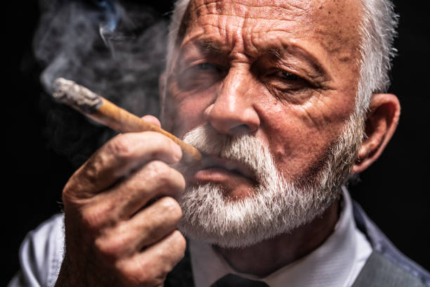 istock Serious senior man who is smoking cigar 1206402650