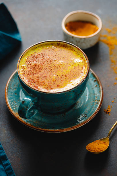 istock Closeup view of turmeric latte cup on a textured dark background. 1206403967