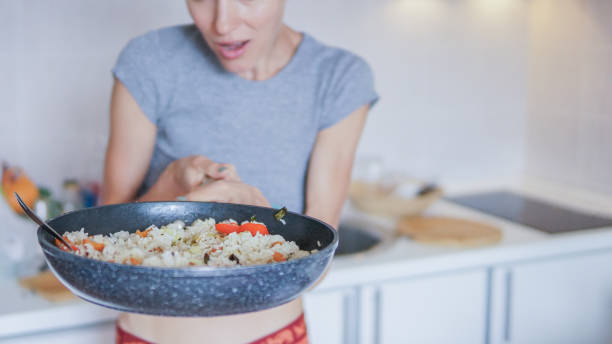 istock Young woman going to eat rice with vegetables 1206405106