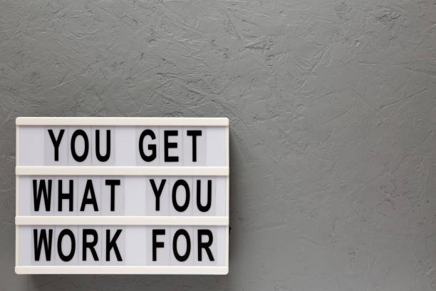 istock 'You get what you work for' words on a lightbox on a gray surface, top view. Overhead, from above, flat lay. Space for text. 1206405740