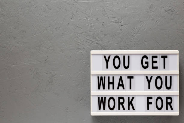 istock 'You get what you work for' words on a lightbox on a gray background, top view. Overhead, from above, flat lay. Space for text. 1206405777