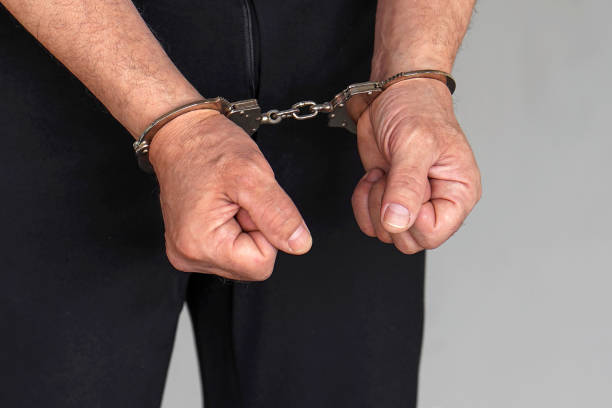 istock Criminal hands locked in handcuffs. Close-up view 1206406836