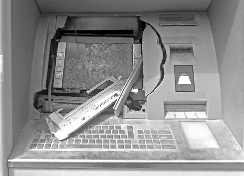 broken ATM machine following a robbery in black and white