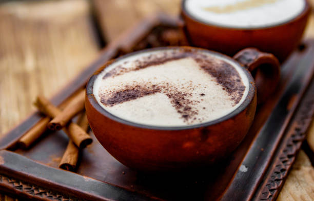 istock Two cups of cappuccino coffee with latte art on woden table background 1206406892