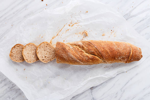 istock Sliced bread on a marble background viewed from above. Whole grain bread on a baking paper. Top view 1206408833